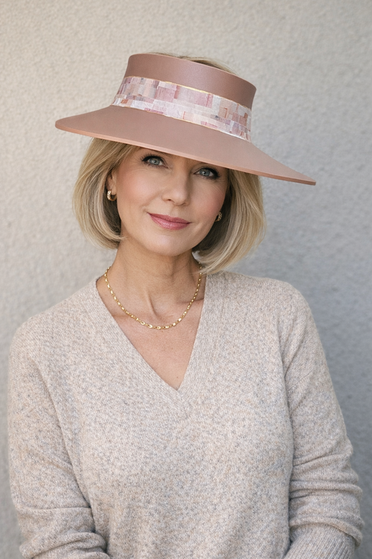 Woman wearing a wide-brimmed hat against a plain background