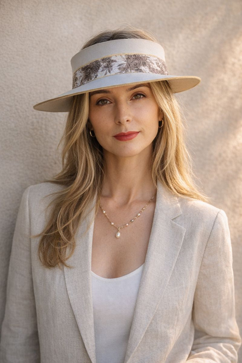 Woman wearing a beige visor hat against a neutral background