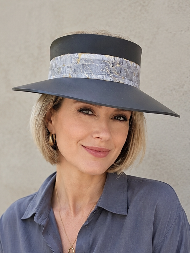 Woman wearing a wide-brimmed hat with a neutral background