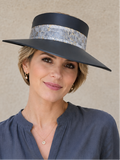 Woman wearing a dark blue hat with a wide brim against a beige background