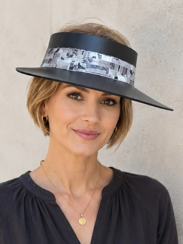 Woman wearing a black visor with floral pattern against a beige wall