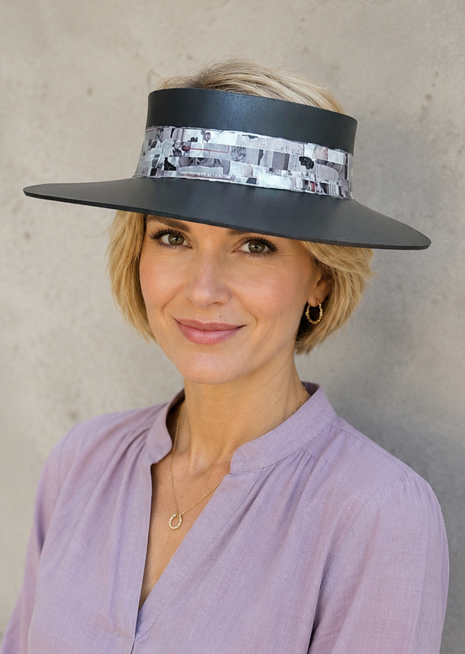 Woman wearing a wide-brimmed hat and a light purple blouse against a neutral background