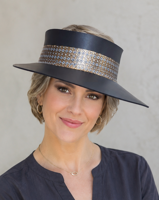 Woman wearing a black hat with a decorative band against a plain background