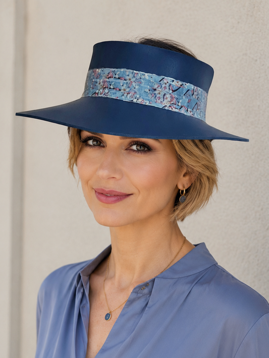 Woman wearing a blue visor and matching blouse against a neutral background