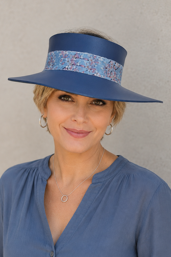 Woman wearing a blue hat and shirt against a plain background