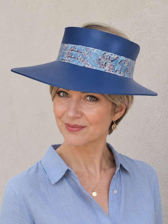 Woman wearing a blue hat with a patterned band against a plain background