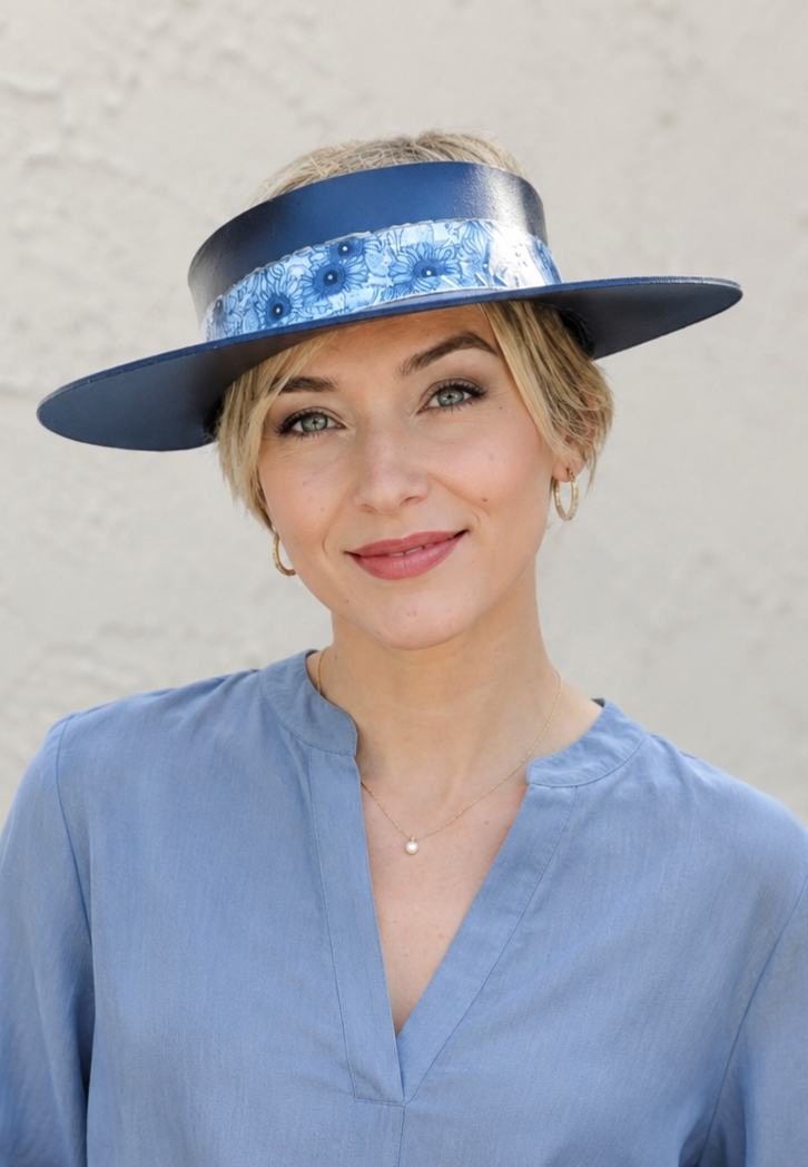 Woman wearing a blue hat with a floral pattern against a plain background
