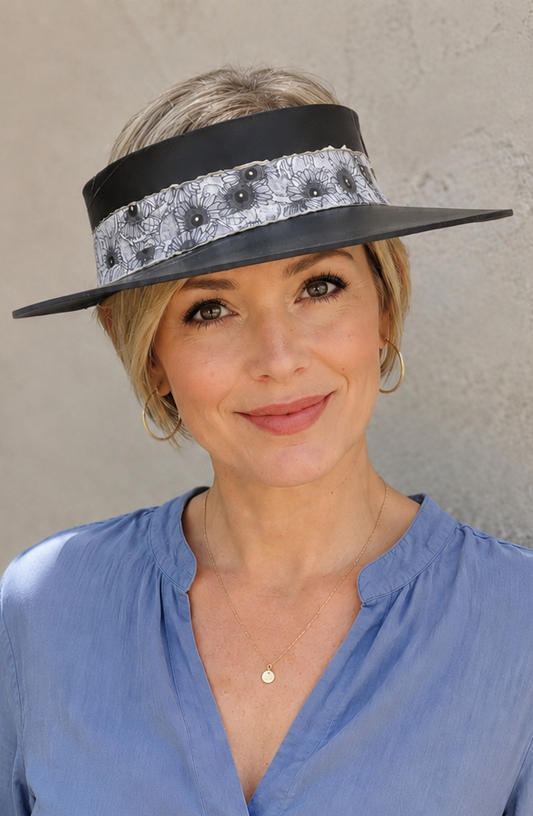 Woman wearing a blue shirt and a decorative visor against a plain background