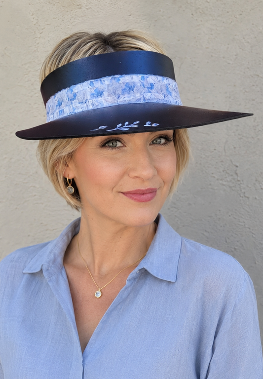 Woman wearing a blue visor and light blue shirt against a neutral background