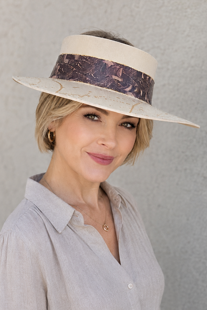 Woman wearing a beige hat with a dark band against a gray background