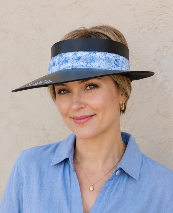 Woman wearing a blue visor with a floral pattern on a beige background