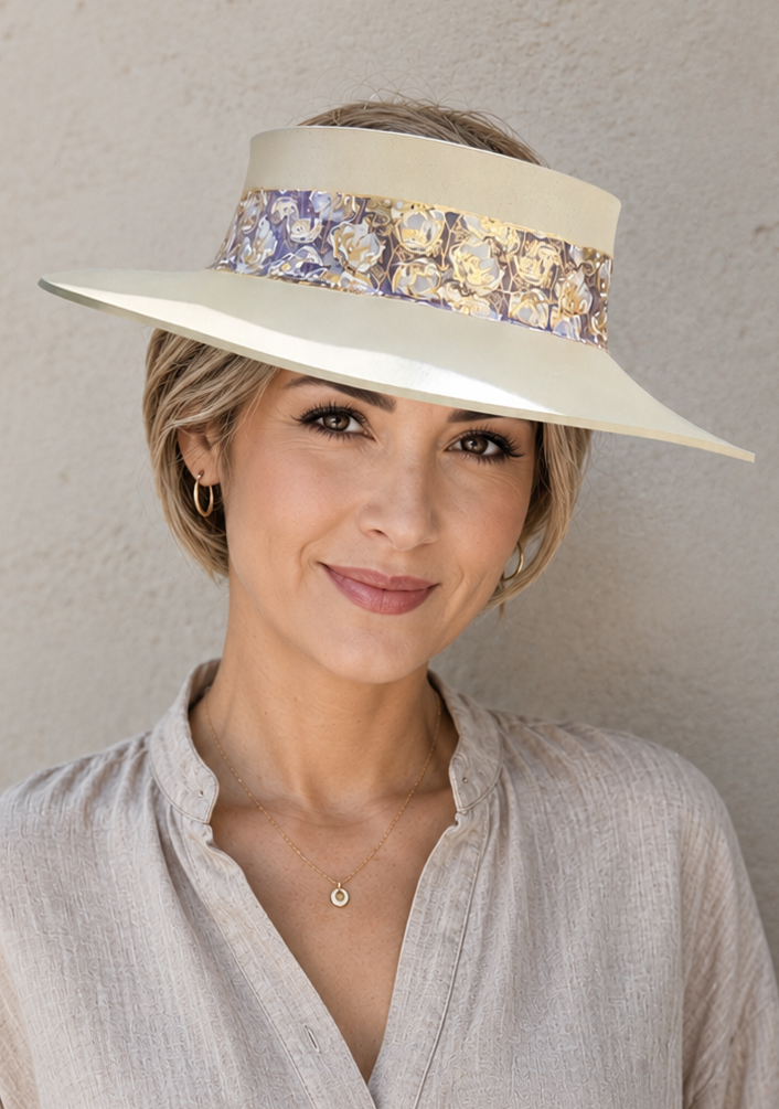 Woman wearing a wide-brimmed hat with floral band against a plain background