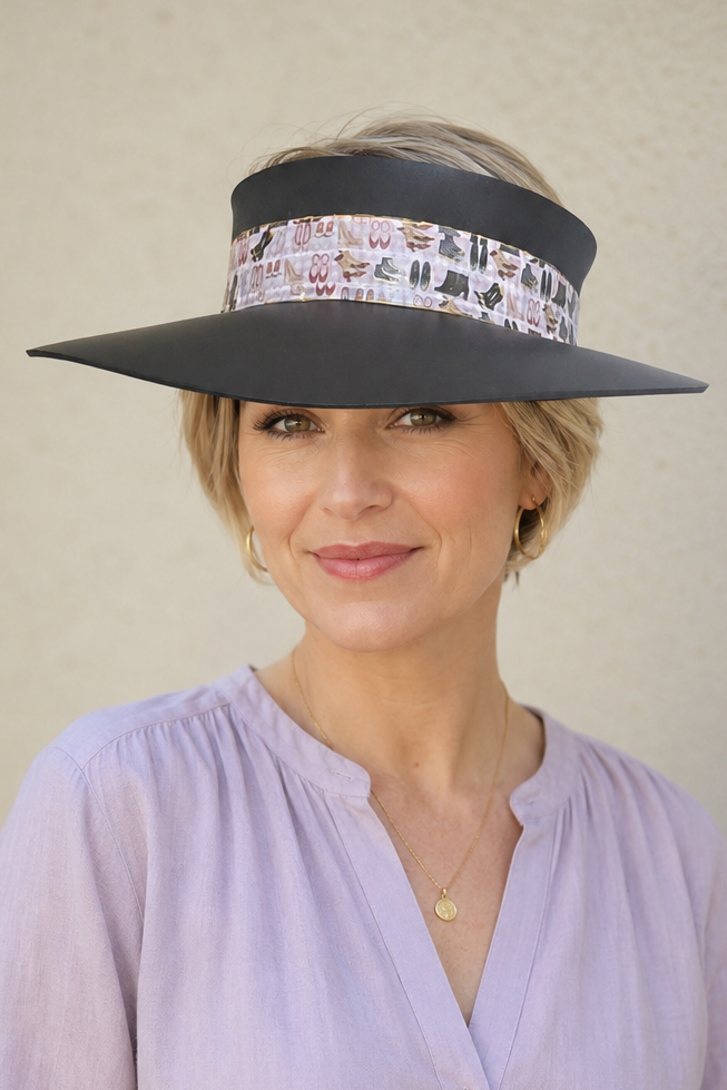 Woman wearing a wide-brimmed hat with a decorative band against a plain background