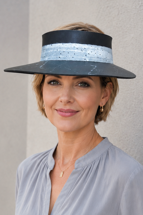 Woman wearing a wide-brimmed hat against a plain background