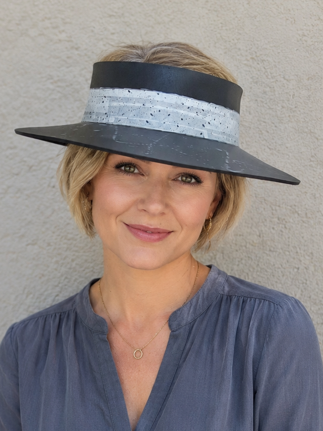 Woman wearing a wide-brimmed hat against a plain background