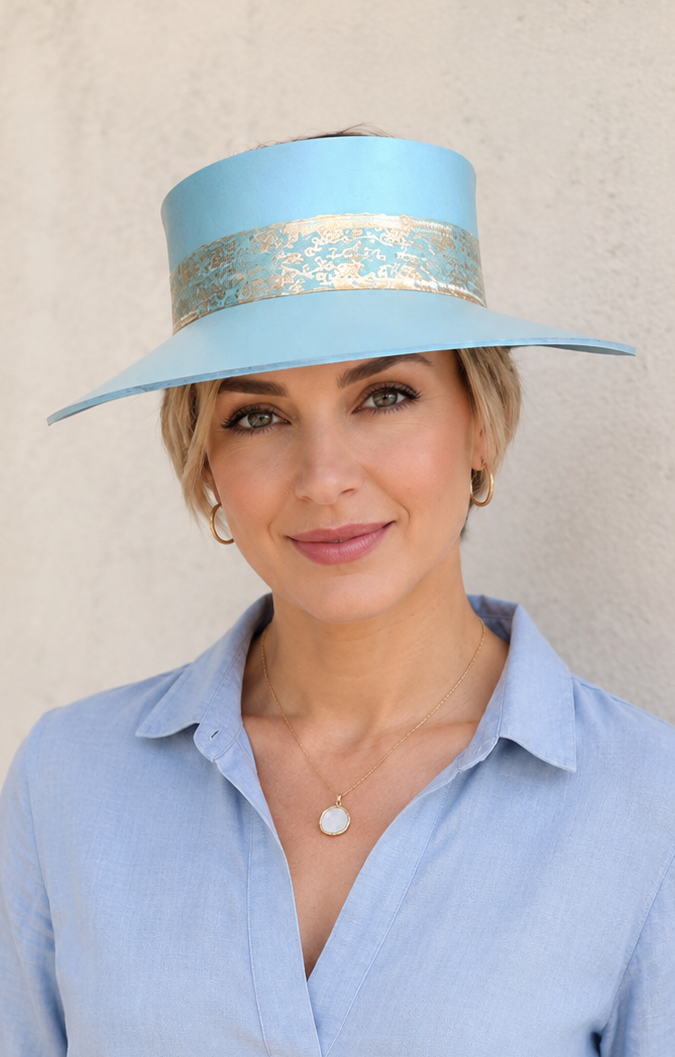 Woman wearing a light blue hat with a decorative band against a beige background
