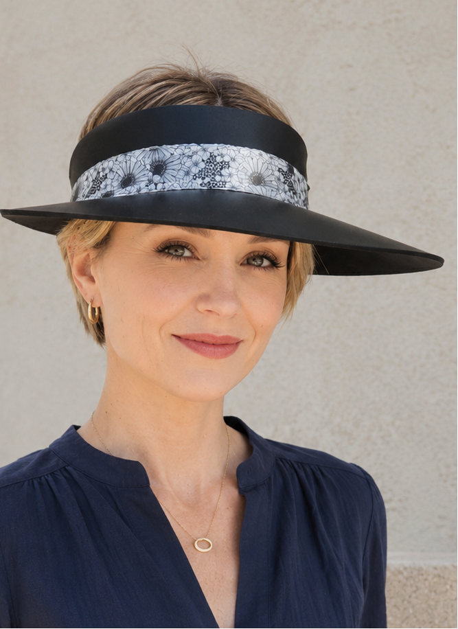 Woman wearing a black visor with a patterned band against a neutral background