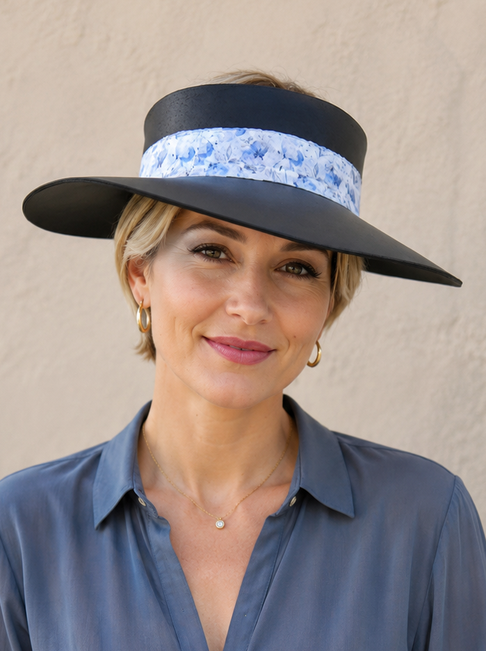 Woman wearing a wide-brimmed hat with a floral band against a beige background