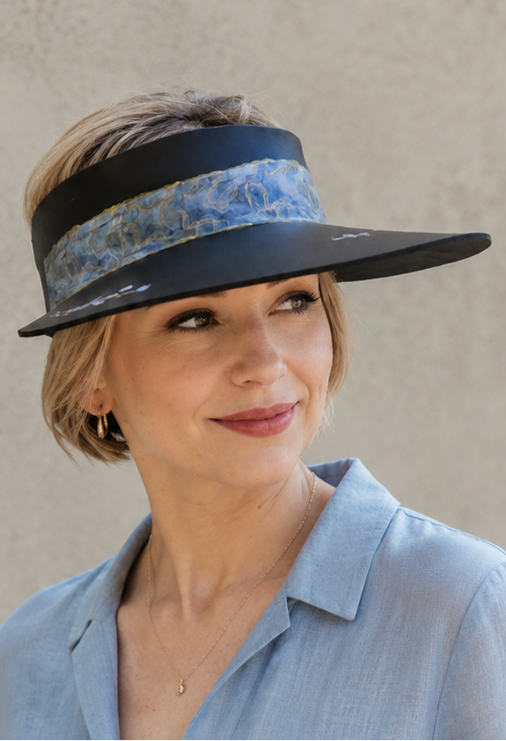 Woman wearing a wide-brimmed hat with a floral band against a plain background