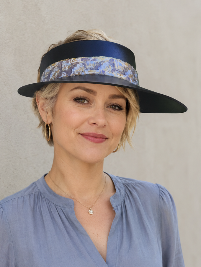 Woman wearing a blue blouse and a decorative visor against a plain background