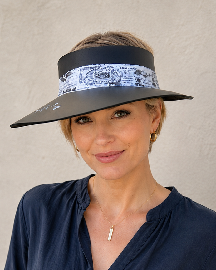 Woman wearing a wide-brimmed hat with a bandana design against a plain background