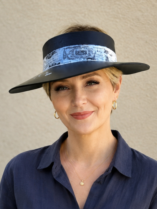 Woman wearing a navy blue visor hat with a patterned band against a beige background