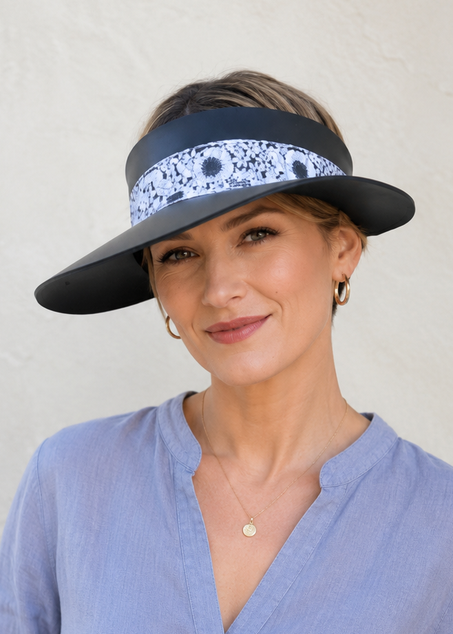 Woman wearing a blue visor with floral pattern on a plain background
