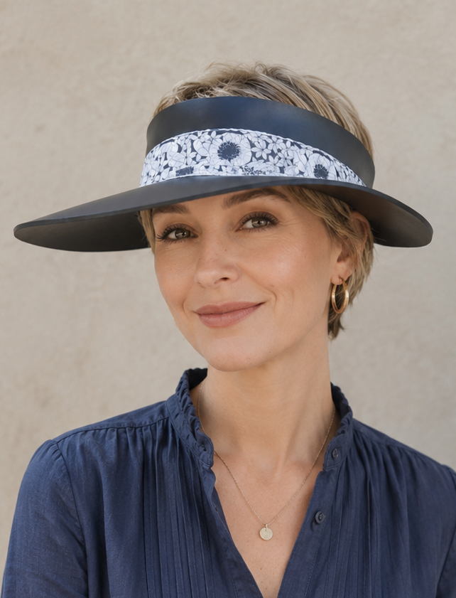 Woman wearing a navy blue visor and button-up shirt against a beige background