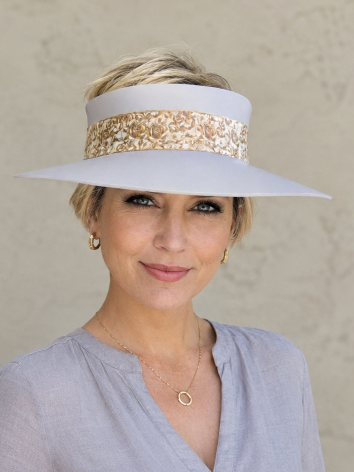 Woman wearing a wide-brimmed hat with decorative band against a plain background