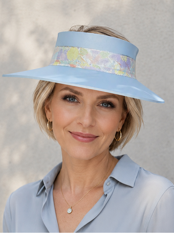 Woman wearing a light blue visor and matching shirt against a neutral background