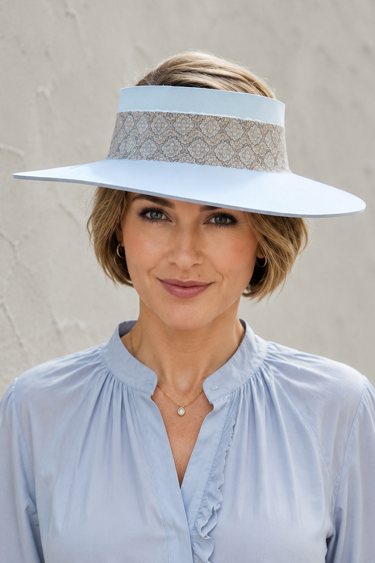 Woman wearing a light blue visor hat and blouse against a neutral background