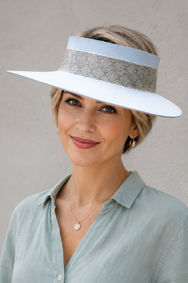 Woman wearing a wide-brimmed hat with a visor against a plain background