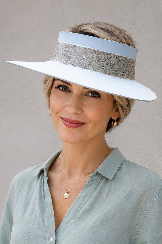 Woman wearing a wide-brimmed hat with a visor against a plain background
