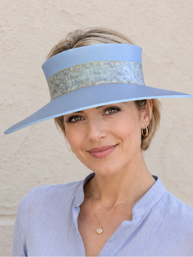Woman wearing a light blue visor and matching shirt against a beige background