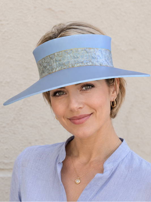 Woman wearing a light blue visor and matching shirt against a beige background