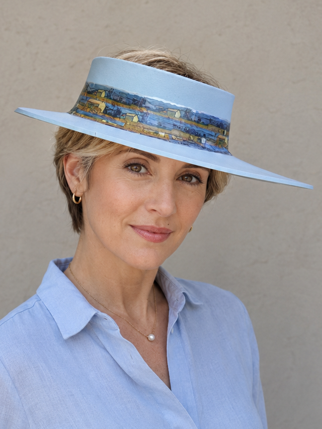 Woman wearing a light blue visor and matching shirt against a beige background
