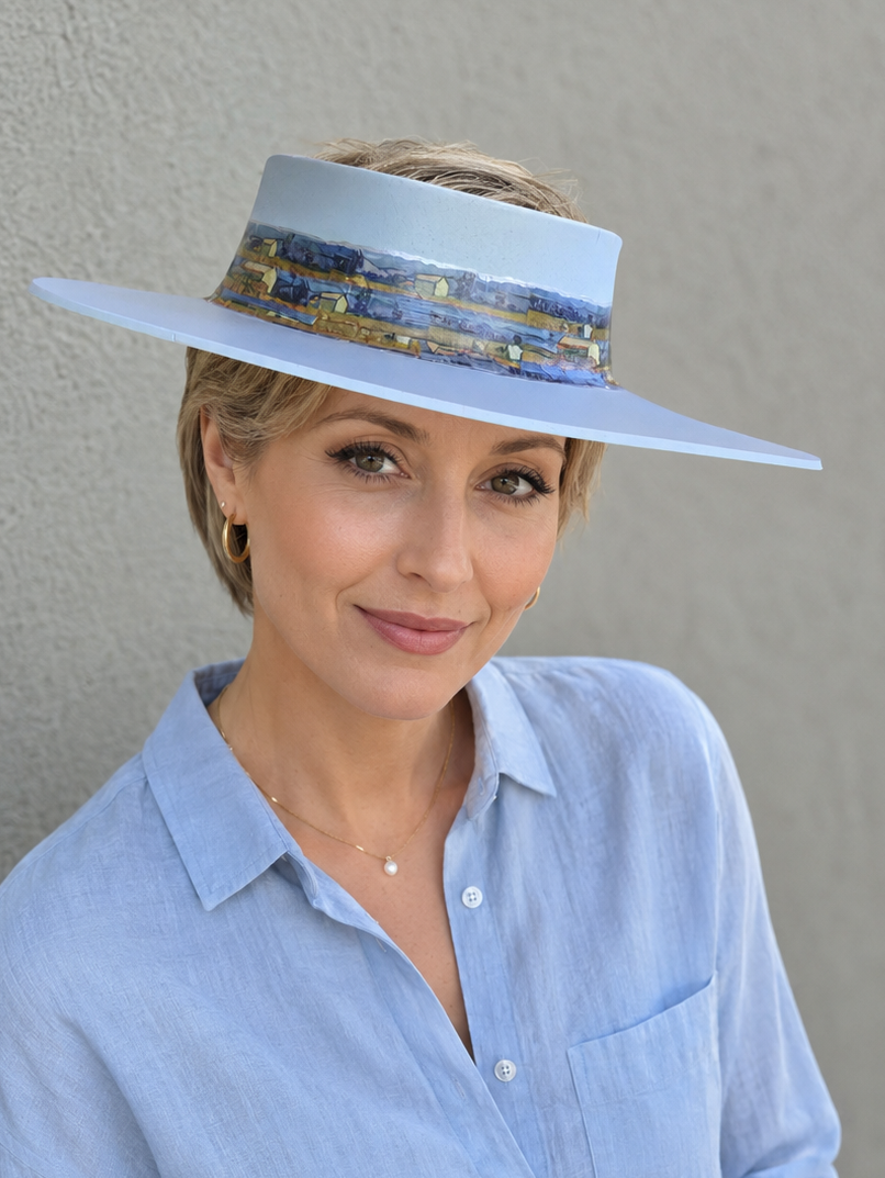 Woman wearing a light blue hat and shirt against a gray background