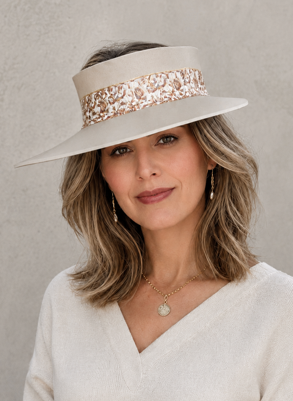 Woman wearing a wide-brimmed hat with a decorative band against a neutral background