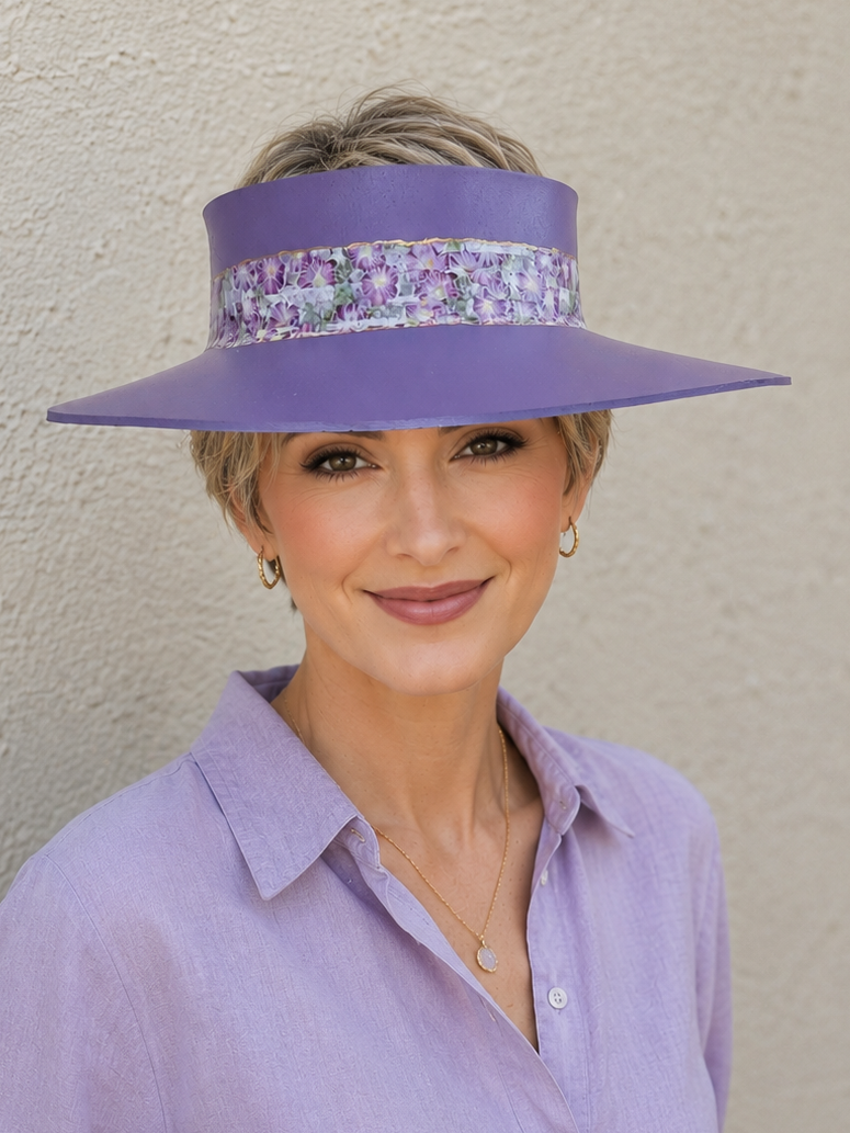 Woman wearing a purple visor and shirt against a plain background