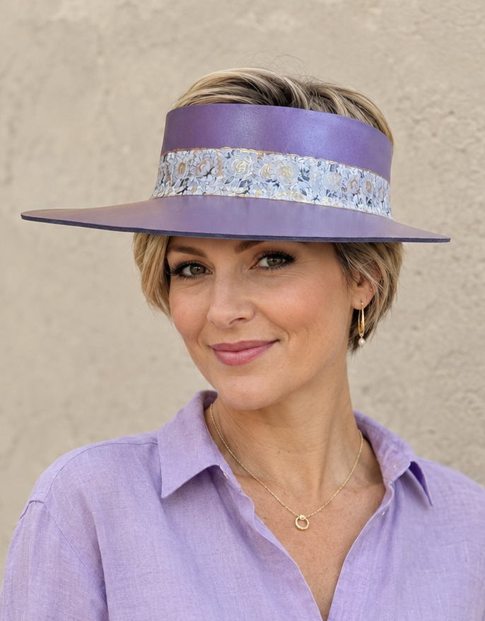 Woman wearing a purple visor and matching shirt against a beige background
