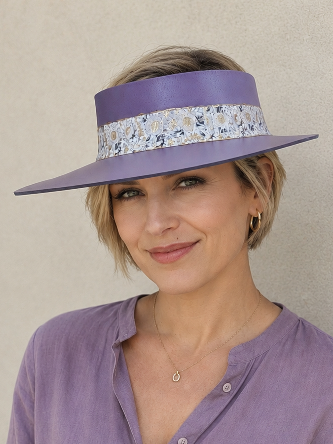 Woman wearing a purple hat with a floral band against a beige background