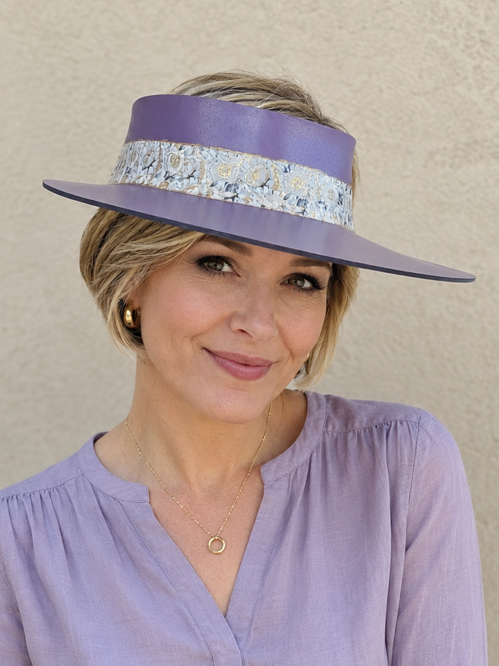 Woman wearing a light purple blouse and visor against a beige background
