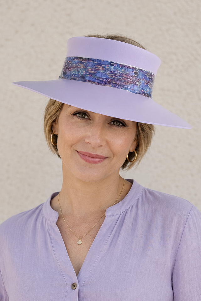 Woman wearing a light purple blouse and hat with a decorative band against a plain background
