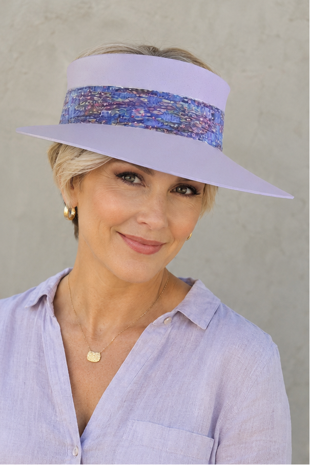 Woman wearing a light purple visor hat with a patterned band against a plain background