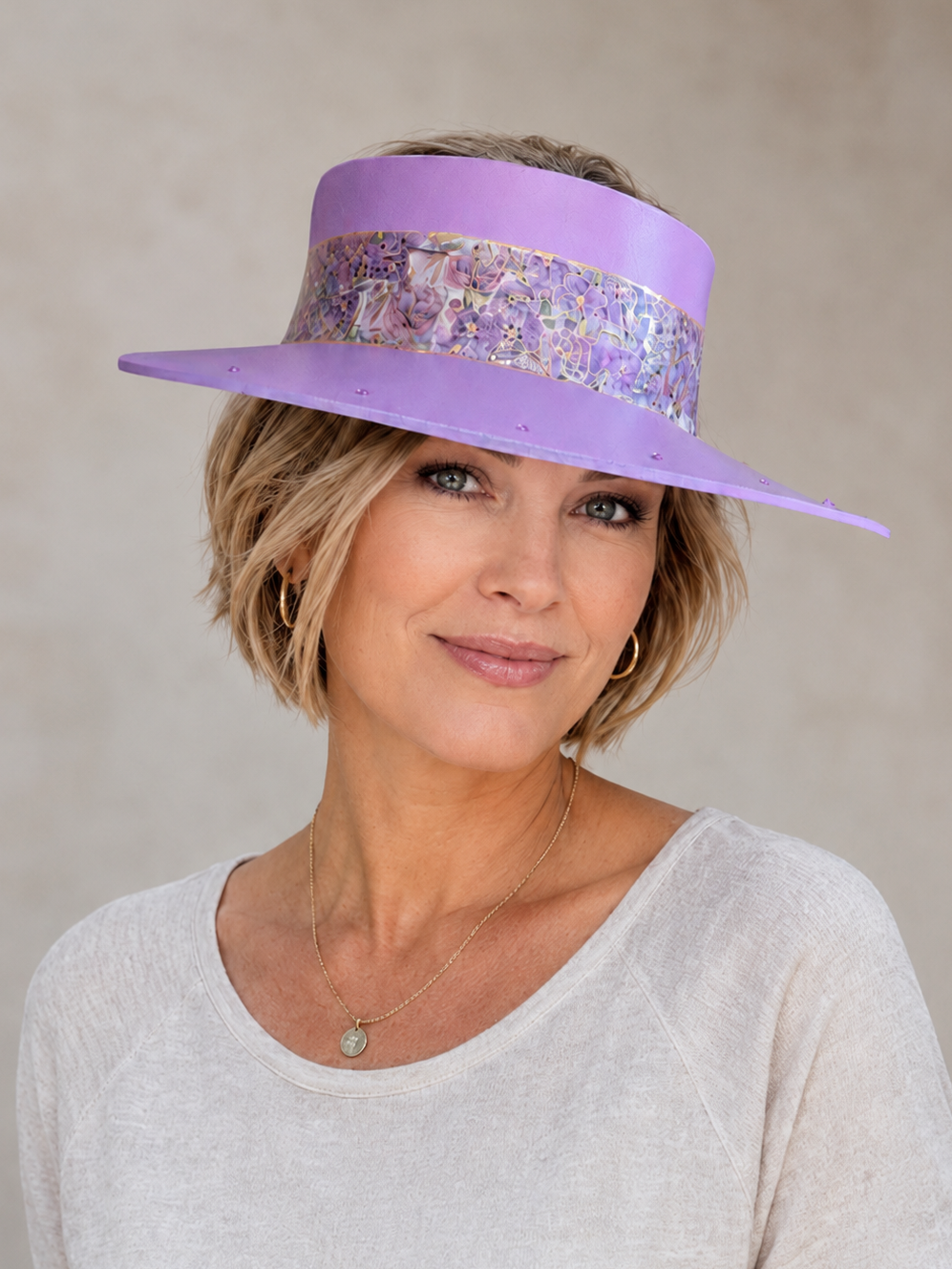 Woman wearing a purple hat with decorative band against a beige background