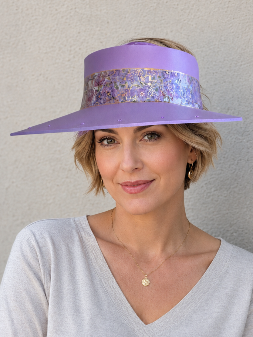 Woman wearing a purple visor with a sequin band against a plain background