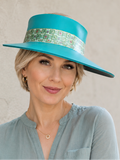 Woman wearing a turquoise hat with a patterned band against a beige background