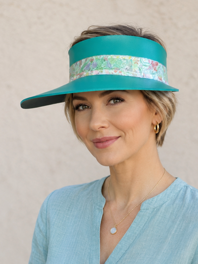 Woman wearing a turquoise visor and light blue shirt against a beige background