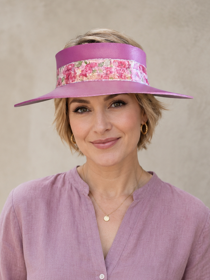Woman wearing a purple visor with floral band against a beige background