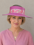 Woman wearing a pink visor with floral band against a beige background